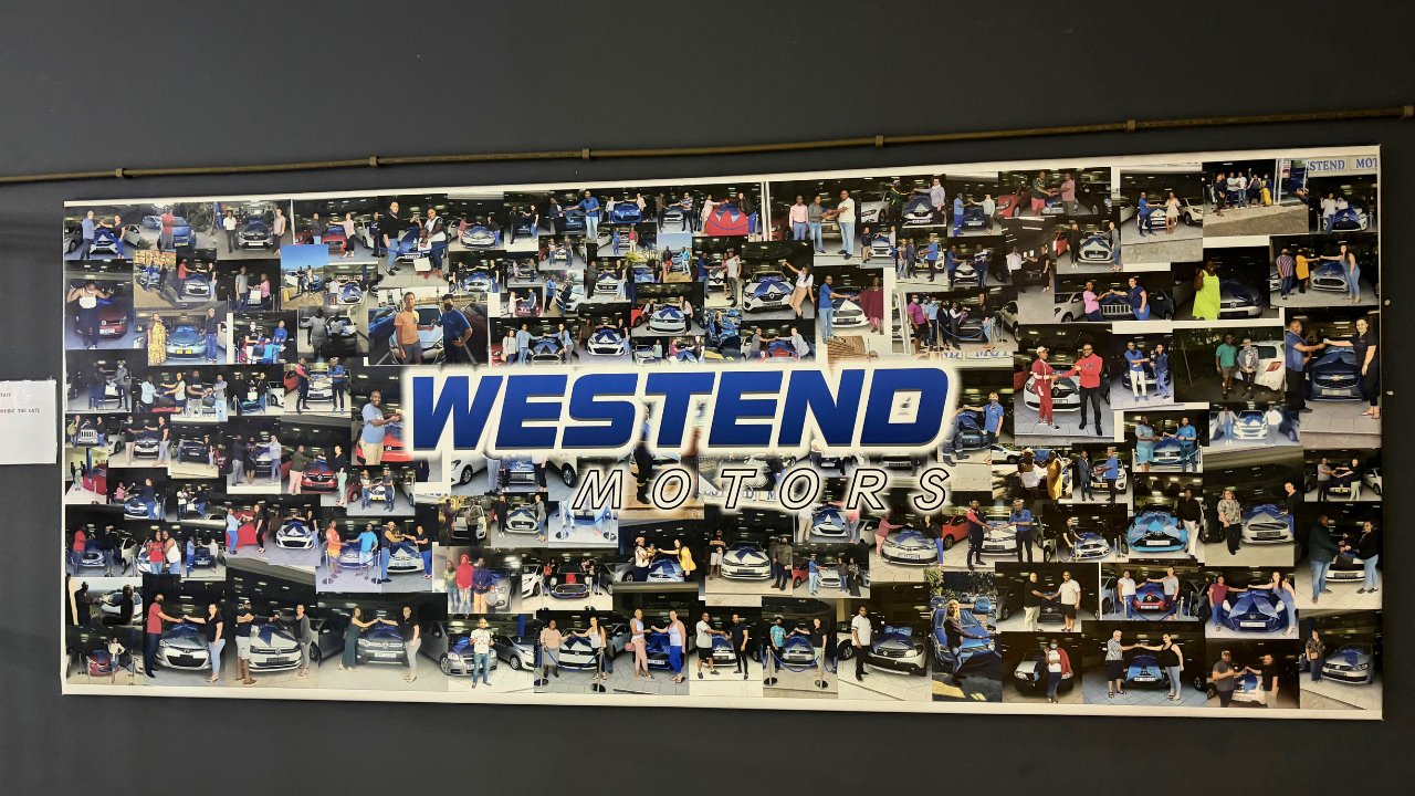 Photo wall in the West End Motors showroom showing hundreds of customers collecting their cars